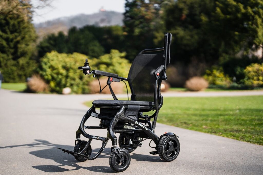 Faltbarer Elektrorollstuhl auf einem Weg im Park